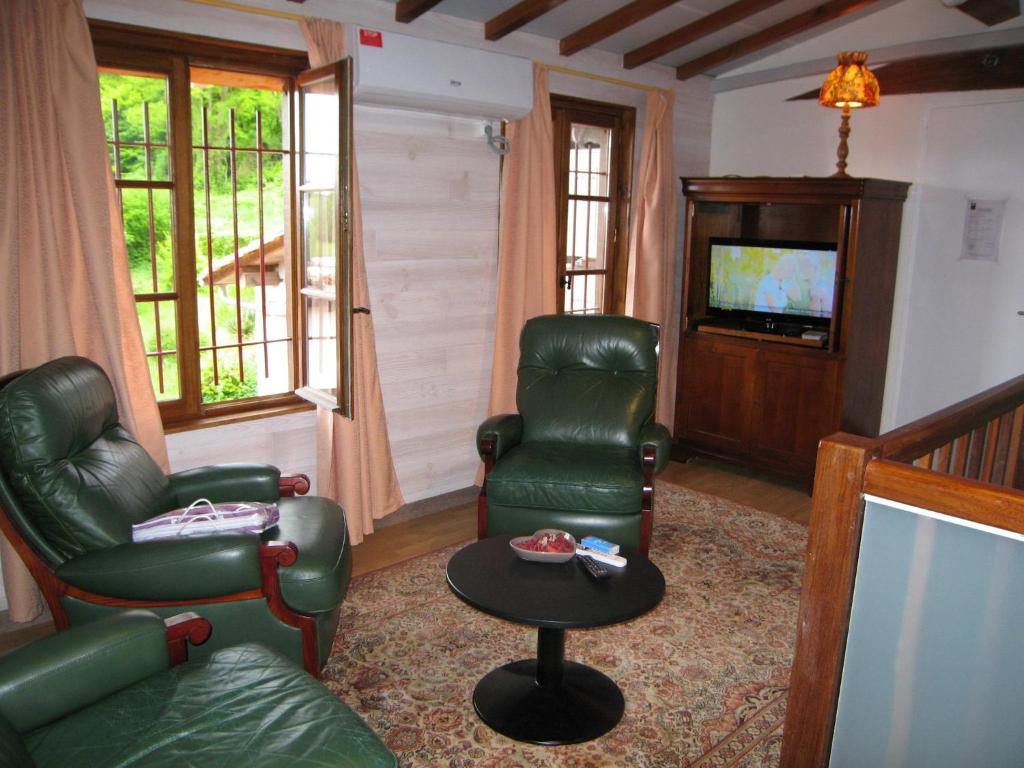a living room with two chairs and a tv at "Côté plage" in Aubeterre-sur-Dronne