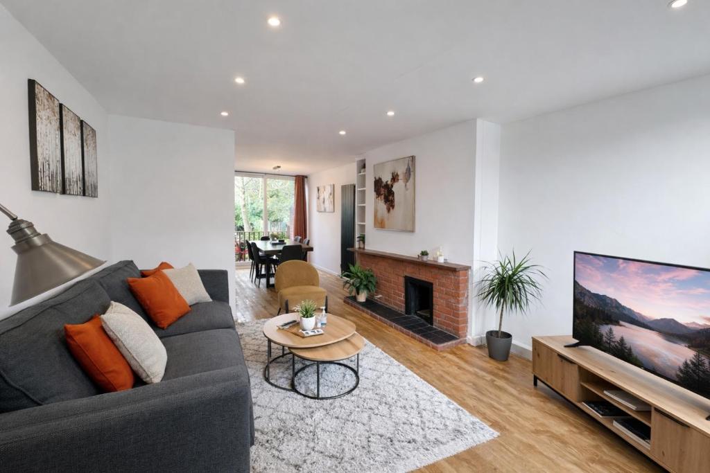 a living room with a gray couch and a fireplace at HollyTree - Family and Business Stay with parking in Cambridge