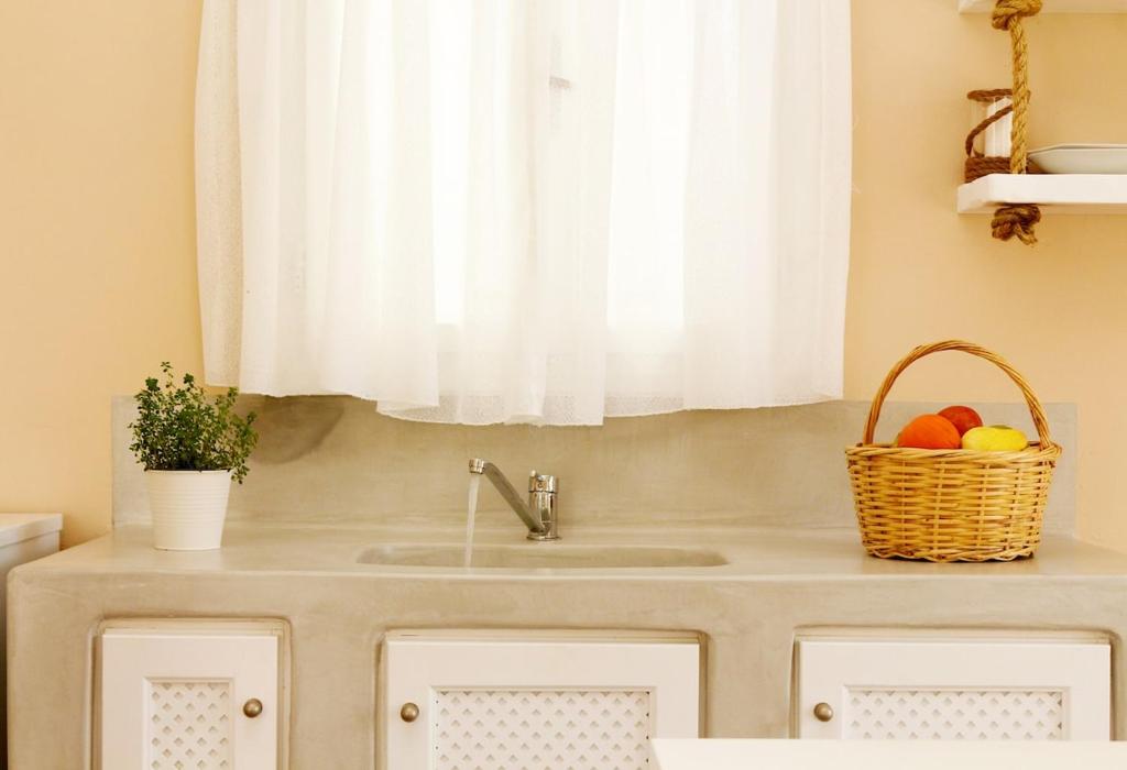 a sink with a basket of fruit in a kitchen at Santa Irini 1 in Vourvoúlos
