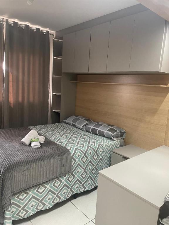 a small bedroom with two beds and a cabinet at Apartamento com piscina in Ponta Grossa