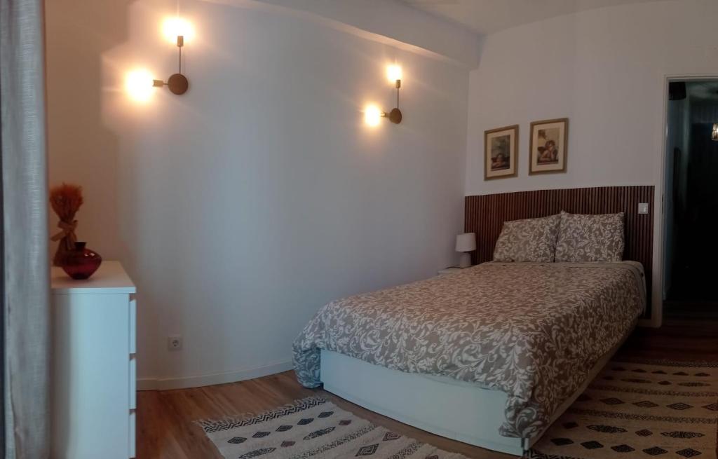 a bedroom with a bed and two lights on the wall at Beach Blue Sesimbra in Sesimbra