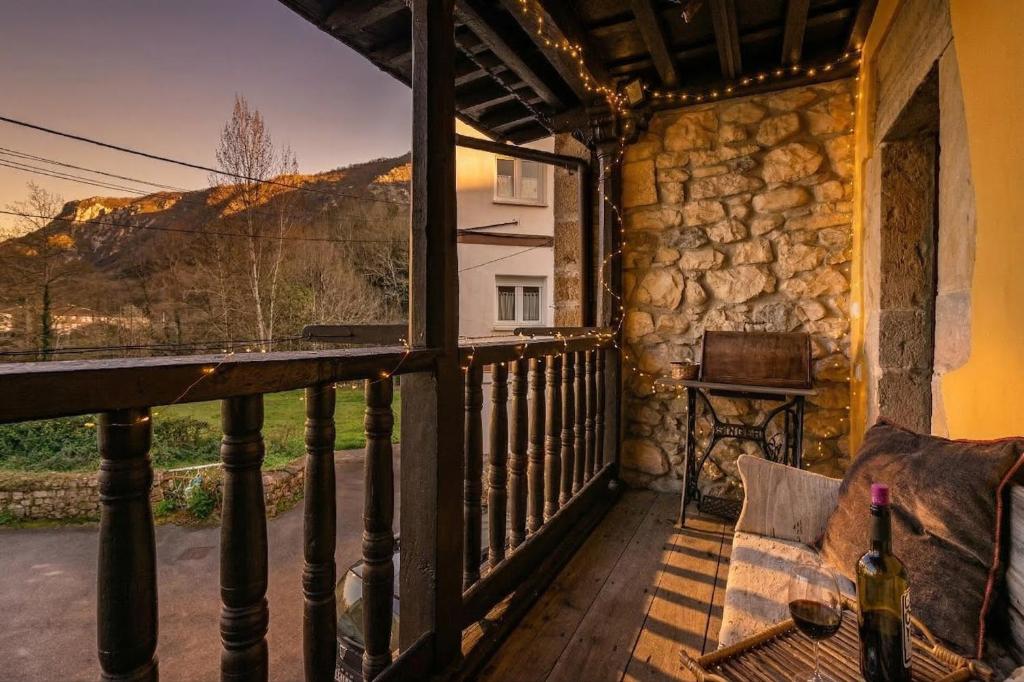 a room with a balcony with a table and a piano at Casa Rural Moradiellos-Cabrales Axtur 4 personas con vistas in Arenas de Cabrales