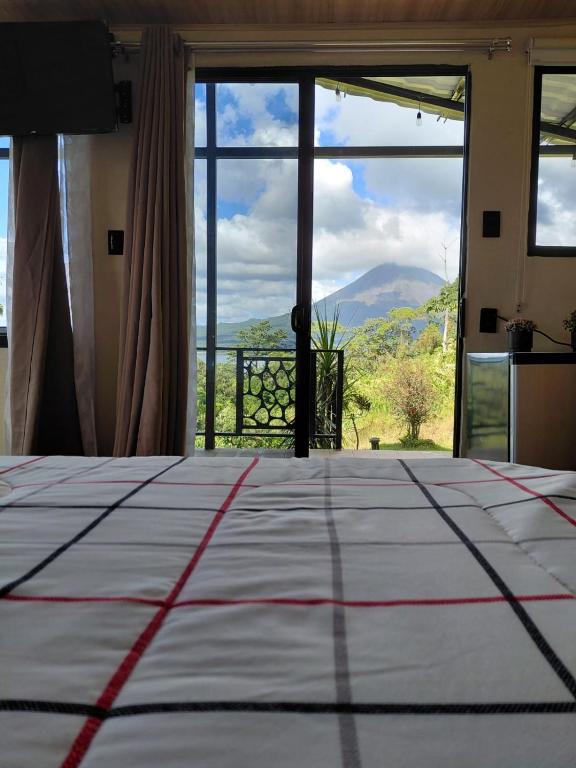 a bedroom with a large bed and a large window at Villa Lago del Sol in El Castillo de La Fortuna