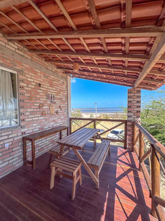 a patio with a picnic table and benches on a deck at Lumoa Beach Chalé Tutoia in Tutóia