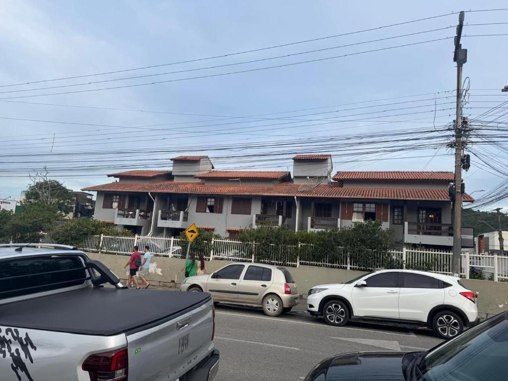 Eine Gruppe von Autos parkte vor einem Haus in der Unterkunft Prédio Jaque in Garopaba