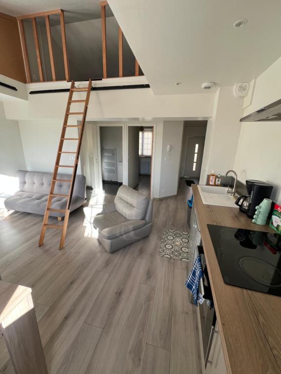a kitchen and living room with a ladder in a room at Maisonnette Montferrandaise proche Tram - 6 couchages - tram - wifi in Clermont-Ferrand