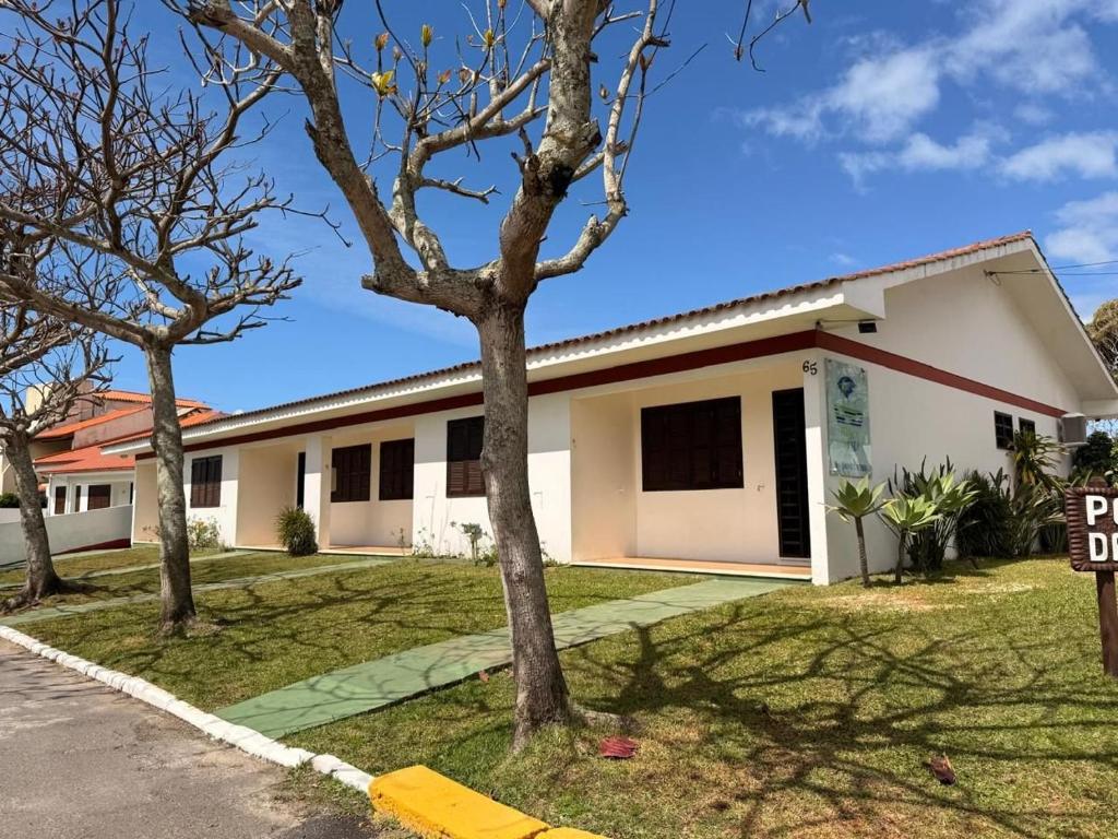 a white house with trees in front of it at Residencial da Villa in Imbituba