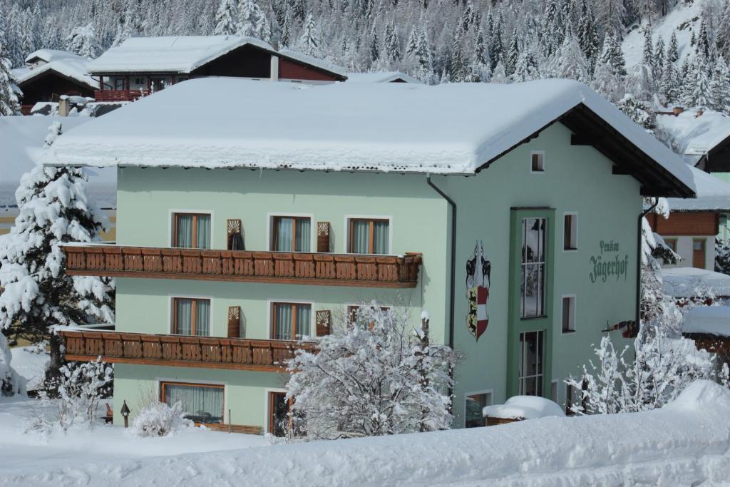 a building with snow on top of it at Pension Jägerhof in Mallnitz