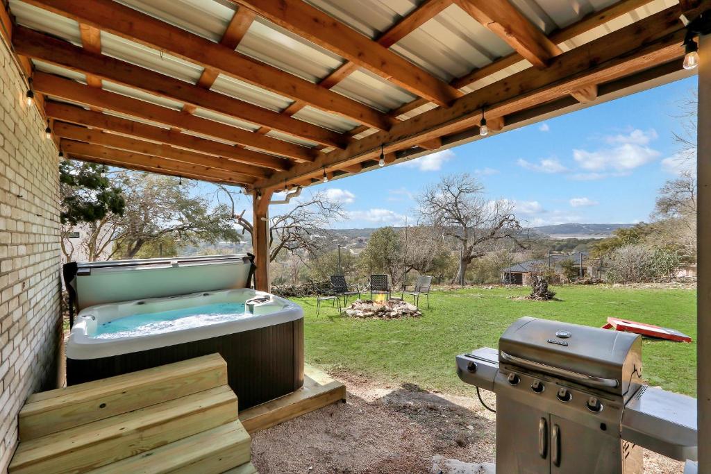 a hot tub and a grill in a backyard at Lakeside Overlook in Canyon Lake
