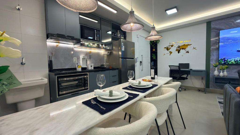 a kitchen with a long dining table and chairs at Ap Studio Premium luxuoso novíssimo! in Sorocaba