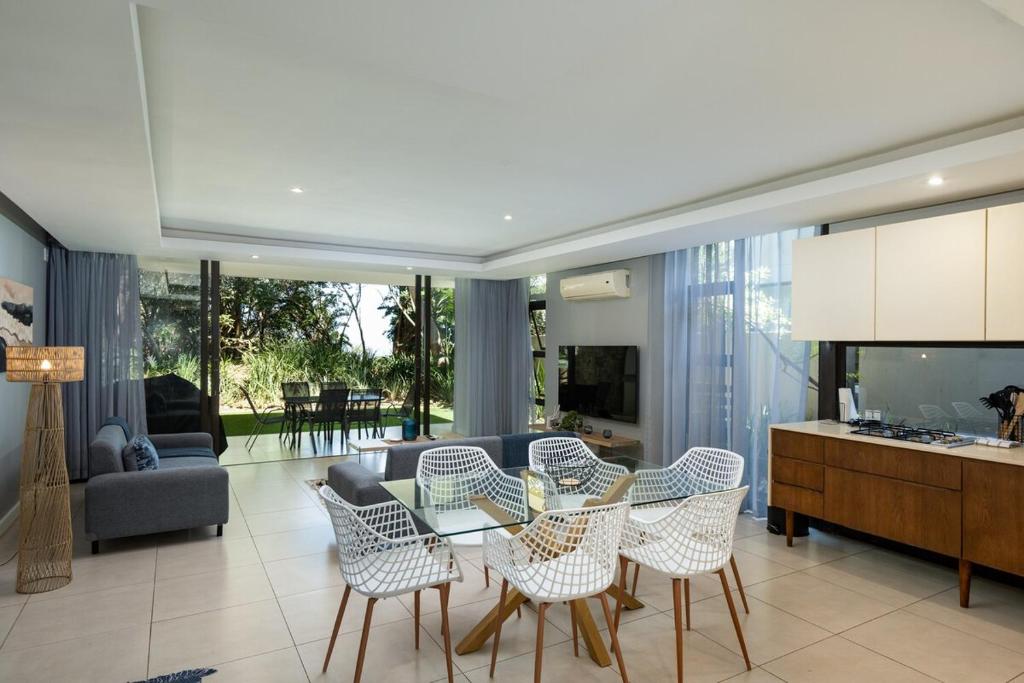 a living room with a glass table and chairs at 23 The Sanctuary Zimbali in Ballito