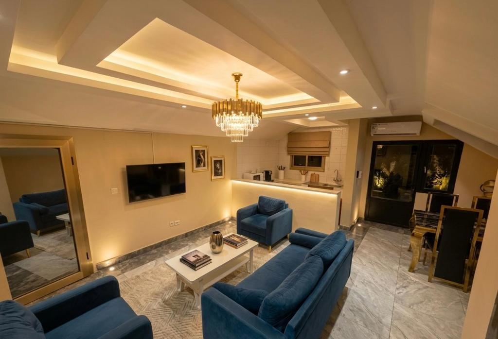 a living room with blue furniture and a chandelier at LKL appartements in Kinshasa