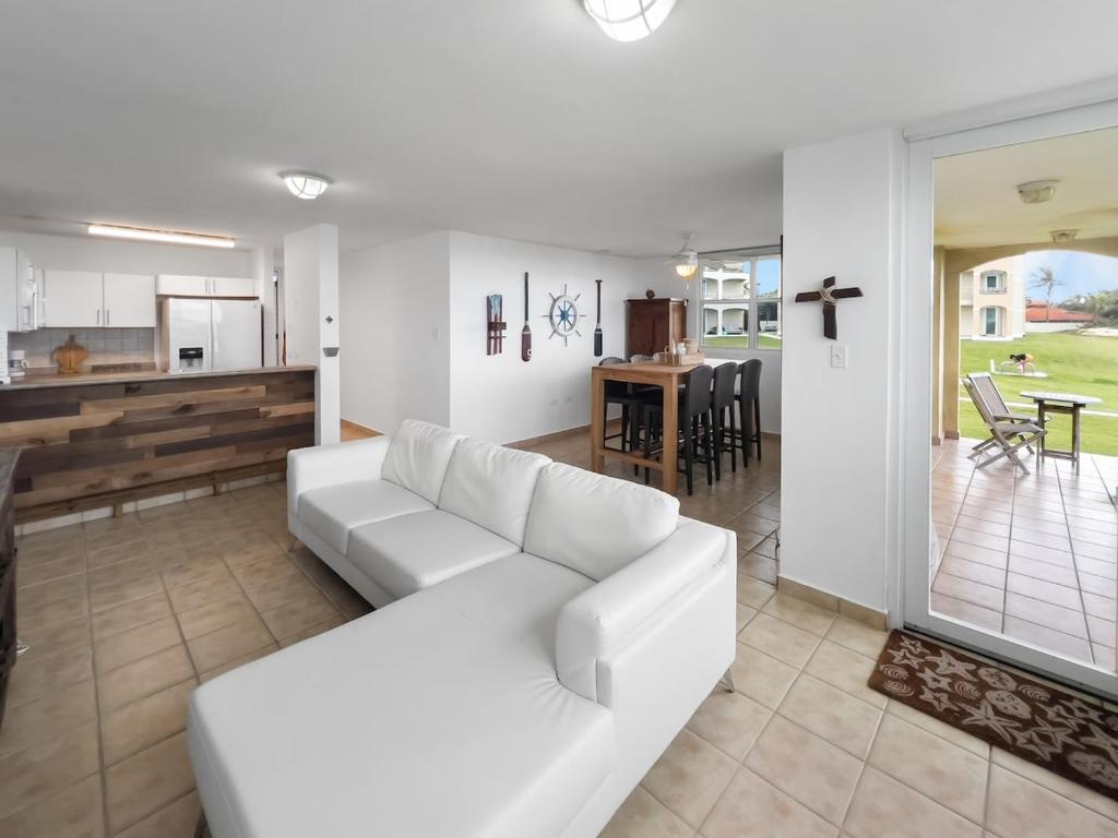a living room with a white couch and a kitchen at Haudimar Beach Apt Ocean Front With Parking in San Antonio