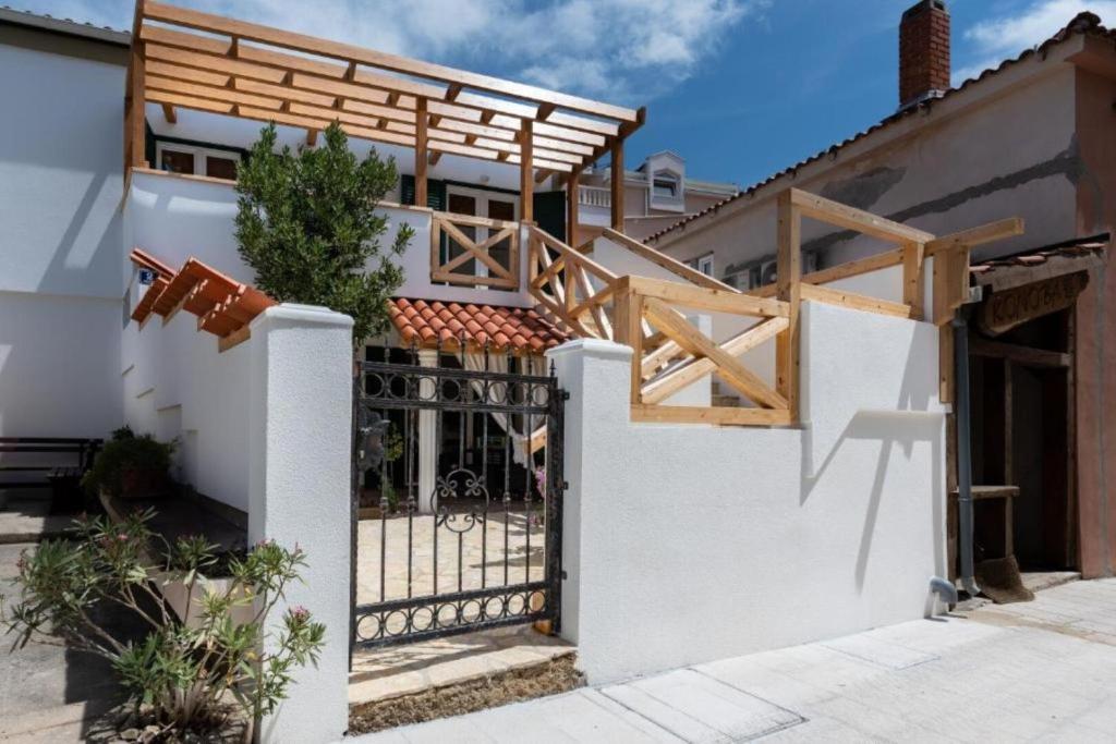 a house with a gate and a fence at Apartment Zdravko near centar in Novalja