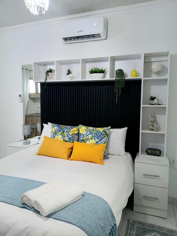 a bedroom with a large bed with yellow pillows at 27 on Donaldbain in Welkom