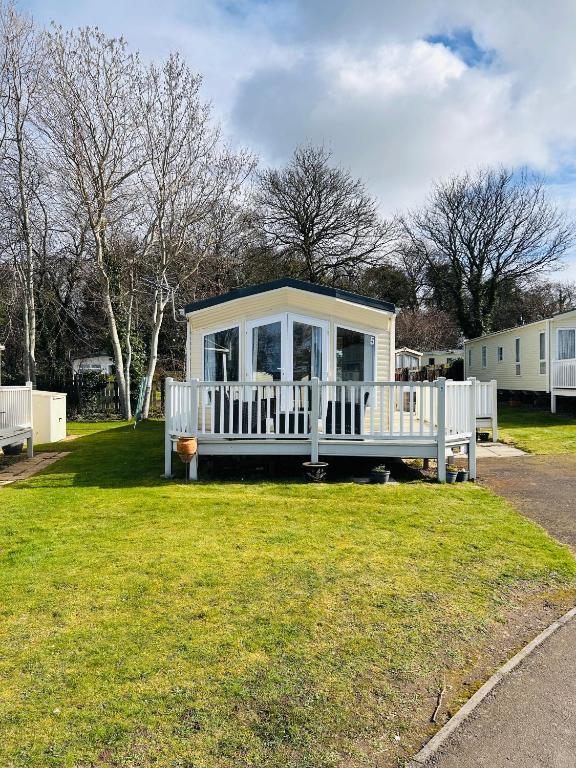 a small white house with a porch in a yard at Edinburgh Lux Lodge Seton Sands in Port Seton