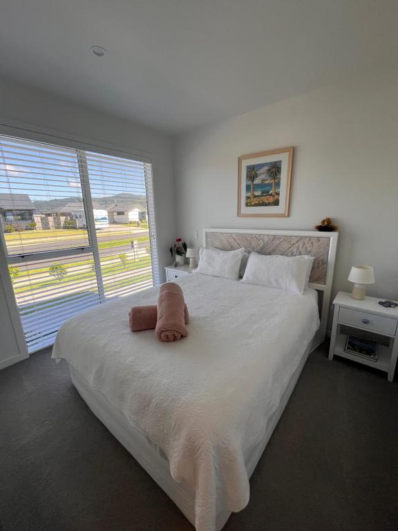 a bedroom with a bed with a stuffed animal on it at Sea Escape in Whitianga