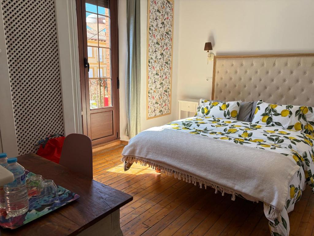 a bedroom with a bed and a table and a window at Casa Balcones in Sahagún