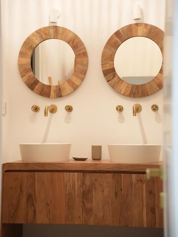 a bathroom with two sinks and two mirrors on the wall at Maison Begani66 in Gaeta