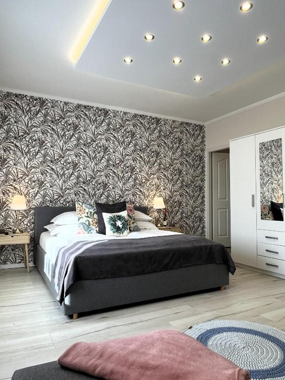 a bedroom with a large bed and a wall mural at Milano Vendégház in Bakonybél