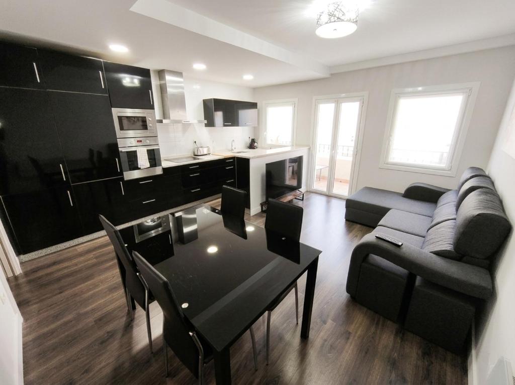 a kitchen and living room with a table and a couch at Apartamento Eguzkey - Tolosa centro in Tolosa
