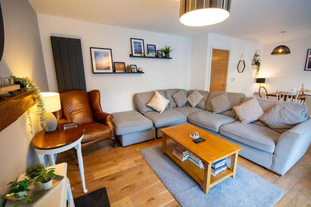a living room with a couch and a table at Pine Cones in Rhoscolyn