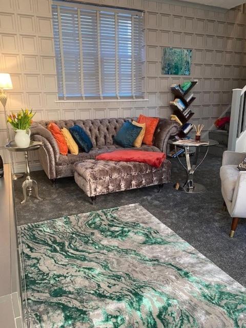 a living room with a couch with colorful pillows at 5 Sea Spray in Burnham on Sea