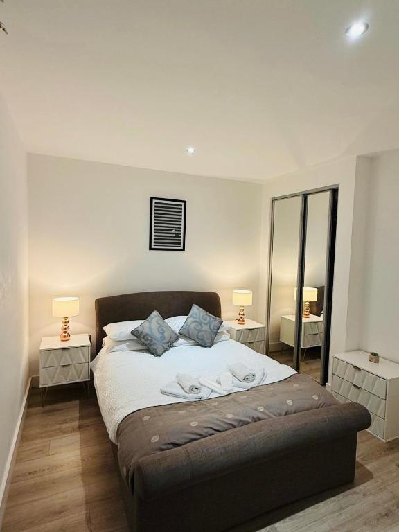a bedroom with a bed with two night stands and two lamps at Stylish studio apartment in Olton