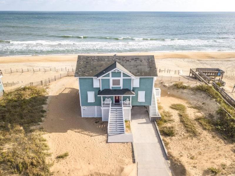 a blue house on the beach next to the ocean at 4000 - Fragile Magic in Kitty Hawk