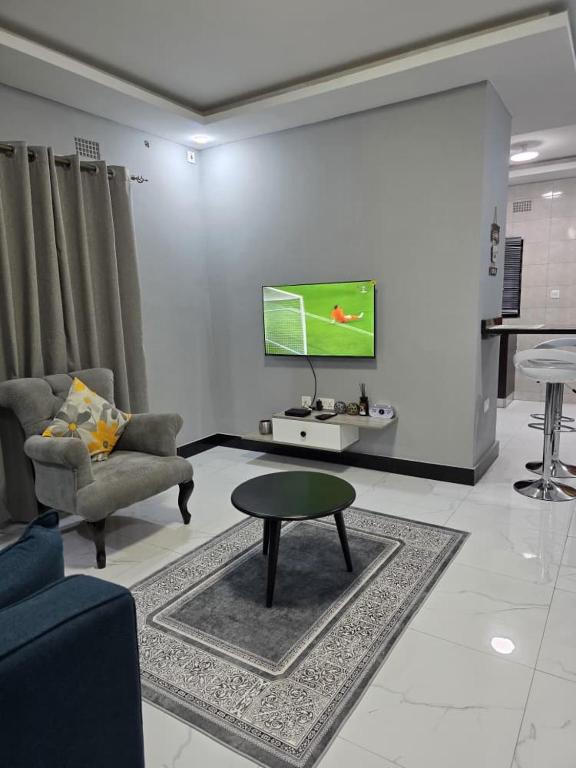 a living room with a tv and a couch and a table at DailyPunch Apartment in Kitwe