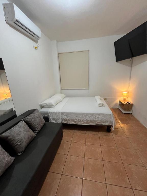 a small room with a bed and a couch at Dulce Hogar in Manta