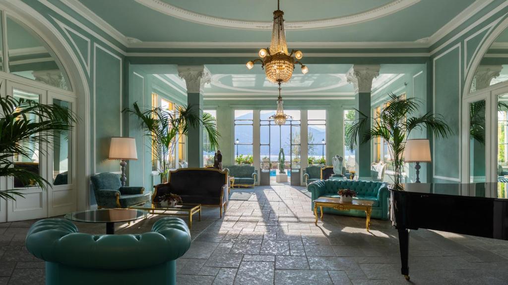 a living room with blue furniture and a chandelier at Grand Hotel Menaggio in Menaggio