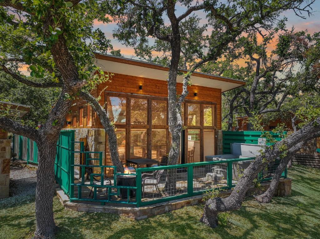 a house with a green fence and trees at Windmill Ranch - Terra Casita #2 in Wimberley