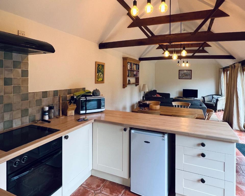 a kitchen with a counter top and a living room at Avocet Cottage in Dunwich