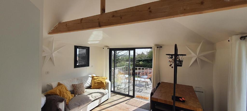 a living room with a couch and a balcony at Cabane Cozy & Calme in Janville