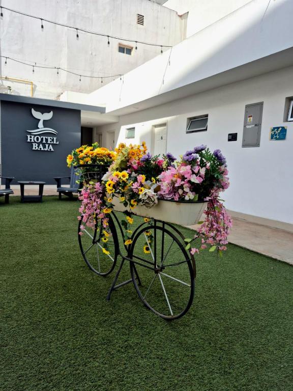 a bike with flowers on it sitting on the grass at Hotel Baja in Tijuana