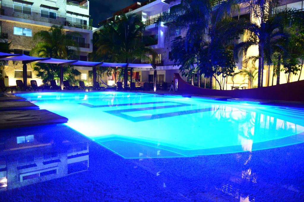 a swimming pool at night with blue lights at Grand Blue Playa in Playa del Carmen