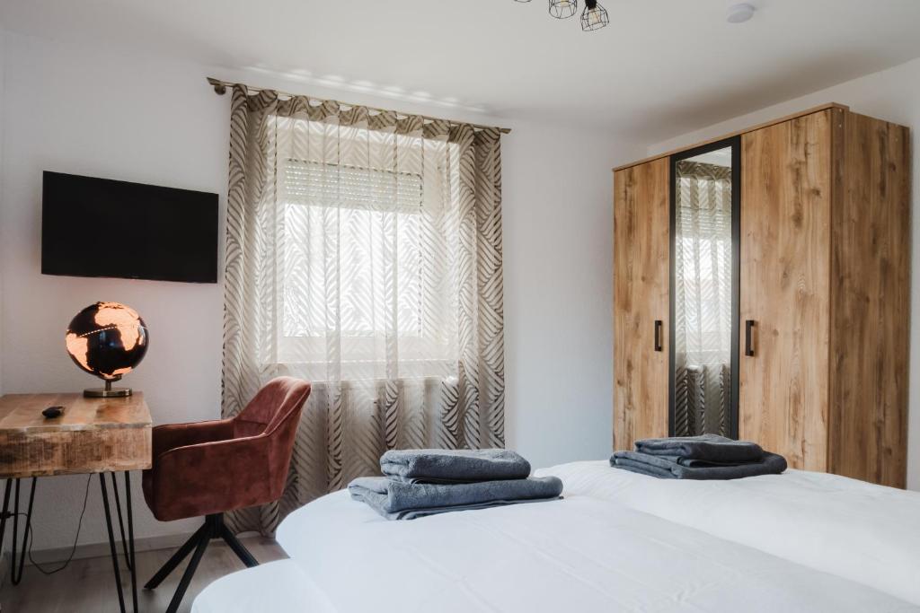 a bedroom with two beds and a desk and a chair at Kokett Apartment in Neu-Ulm