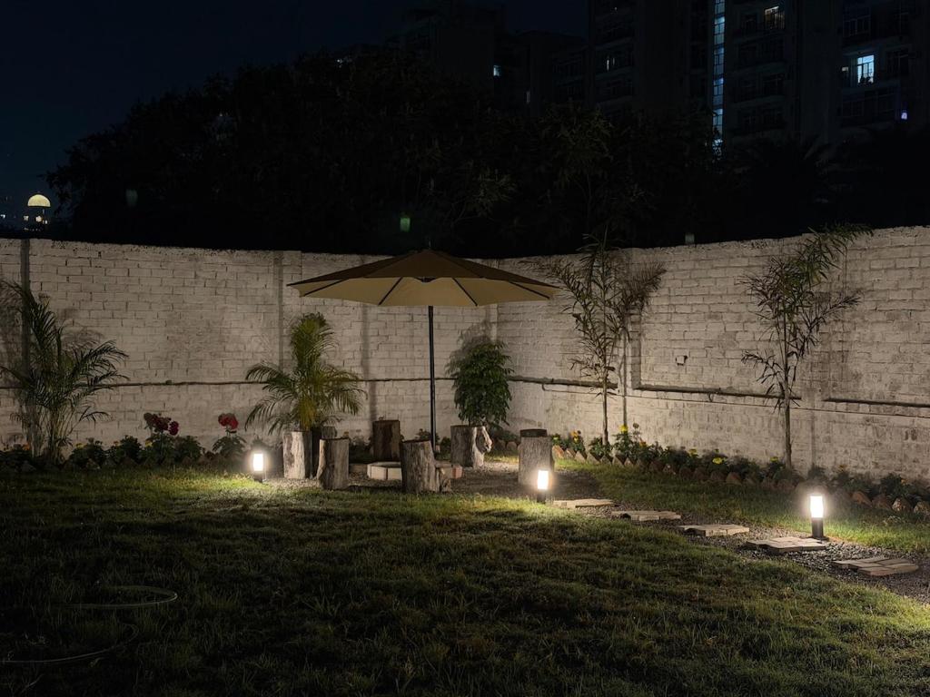 a table with an umbrella in a yard at night at Palm Stone Villa in Lucknow