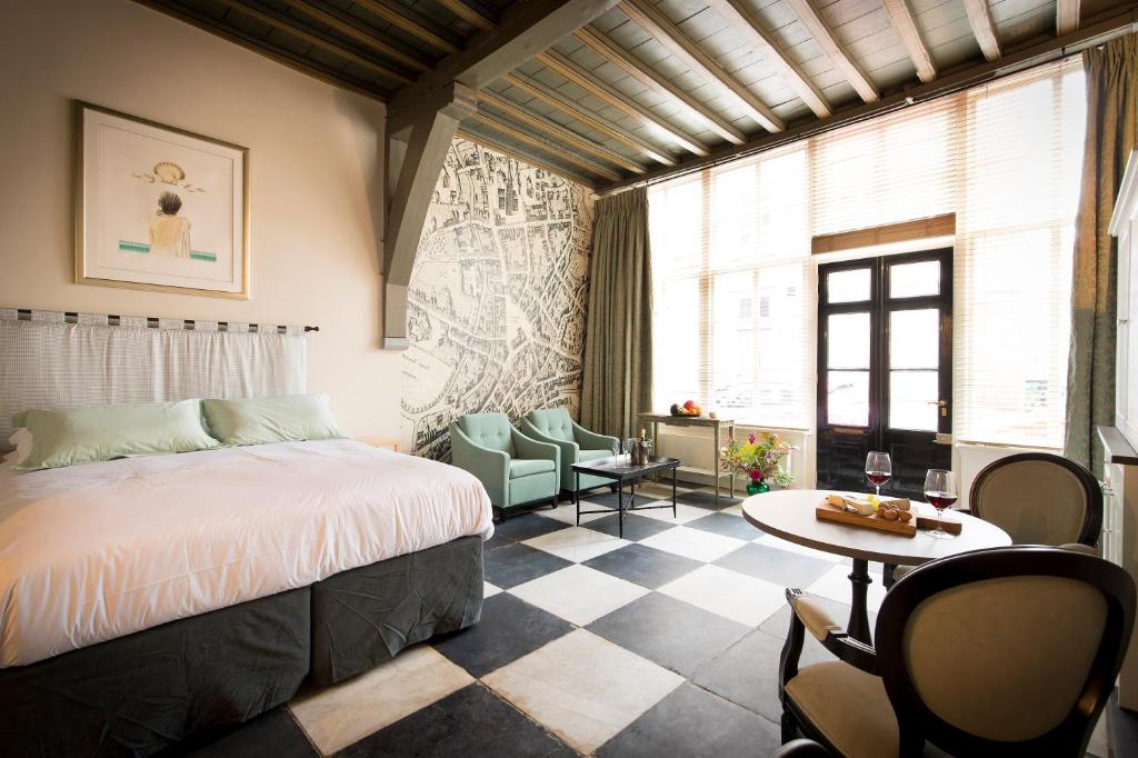 a bedroom with a bed and a table and chairs at Uylenhof Hotel in Den Bosch