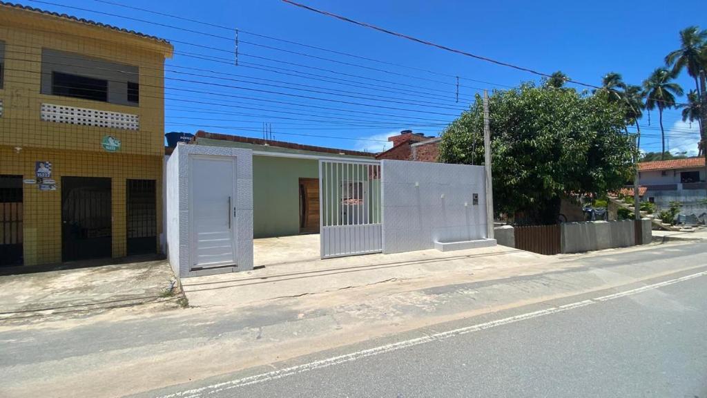 a building with a gate on the side of a street at Casa Aconchego in Japaratinga