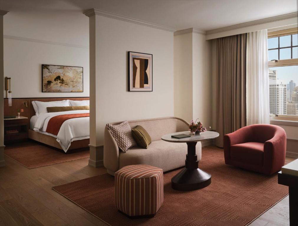 a hotel room with a bed and a couch and a table at The Huntington Hotel in San Francisco