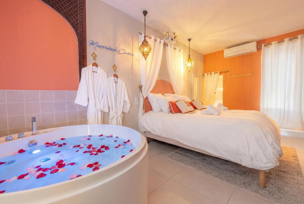 a bedroom with a tub next to a bed at Marrakech Cinéma Jacuzzi - Suite romantique in Feyzin