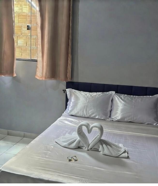 two swans forming a heart on a bed at Casa na nova maraba in Marabá