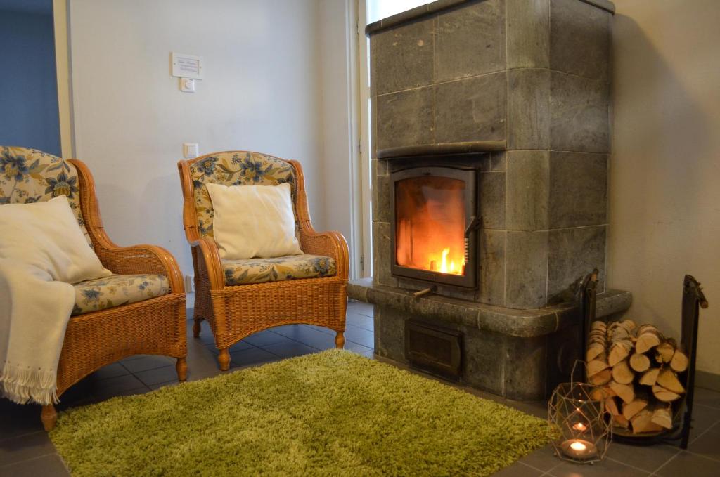 a living room with two chairs and a fireplace at Rauhalahti Holiday Homes in Kuopio