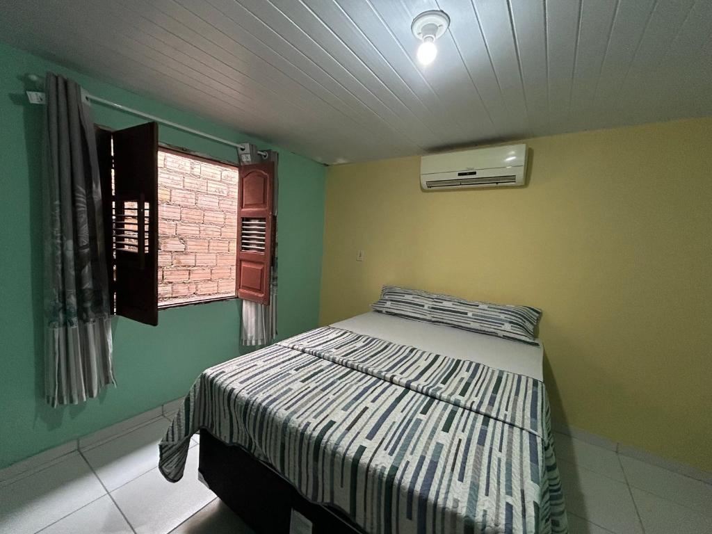 a bedroom with a bed and a window at Quarto Ilha do amor in Santarém