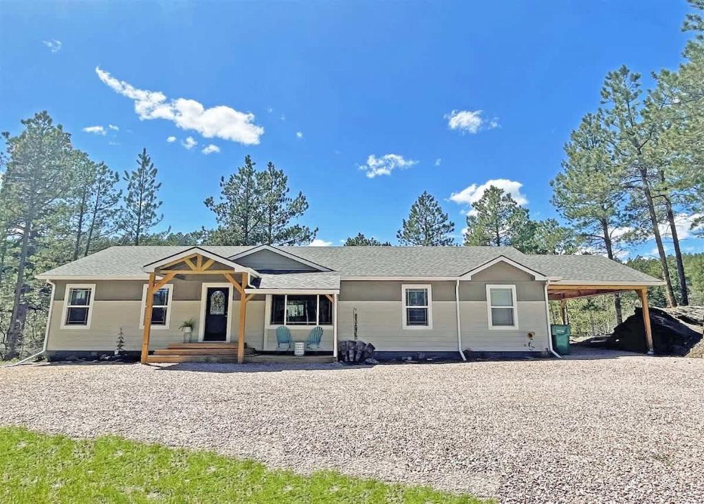 a house on a gravel driveway with trees in the background at Battle Creek Station in Keystone