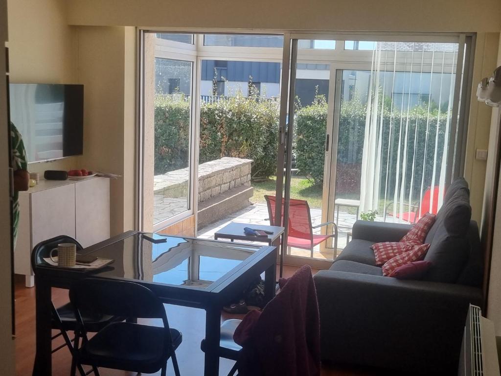 a living room with a couch and a table and chairs at Appartement 30 m de la mer in La Turballe