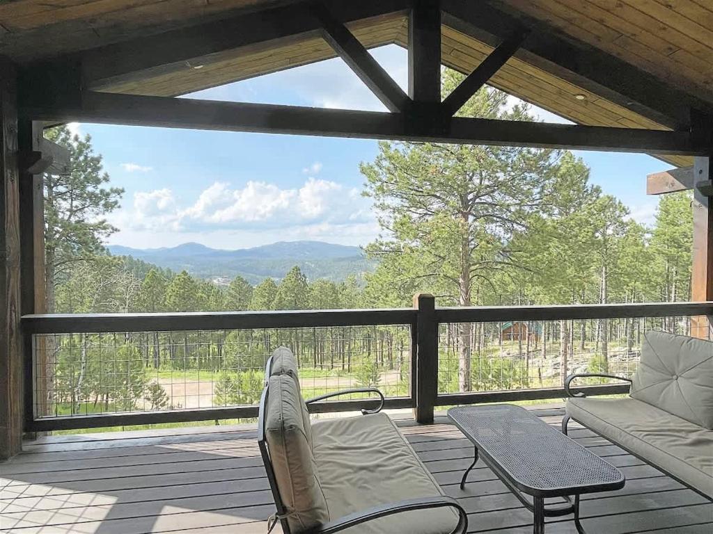a screened in porch with a view of the mountains at Bishop Mountain Lookout in Hill City