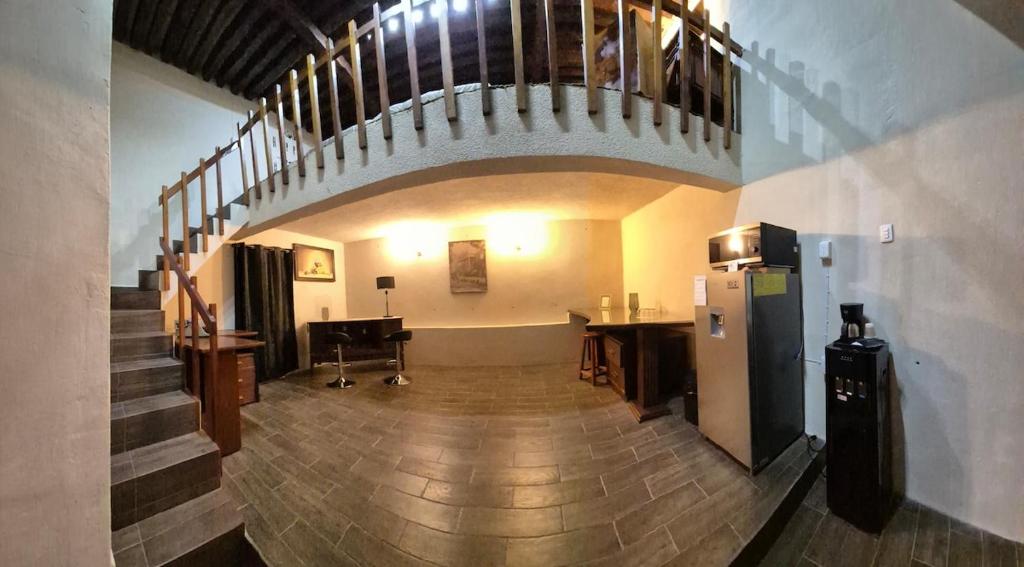 a large room with a staircase and a refrigerator at Casa de Chacha in Guanajuato
